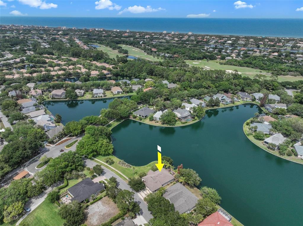 An aerial view shows a house with a yellow arrow pointing to its roof — 5 SANDPIPER COURT, PALM COAST, FL
