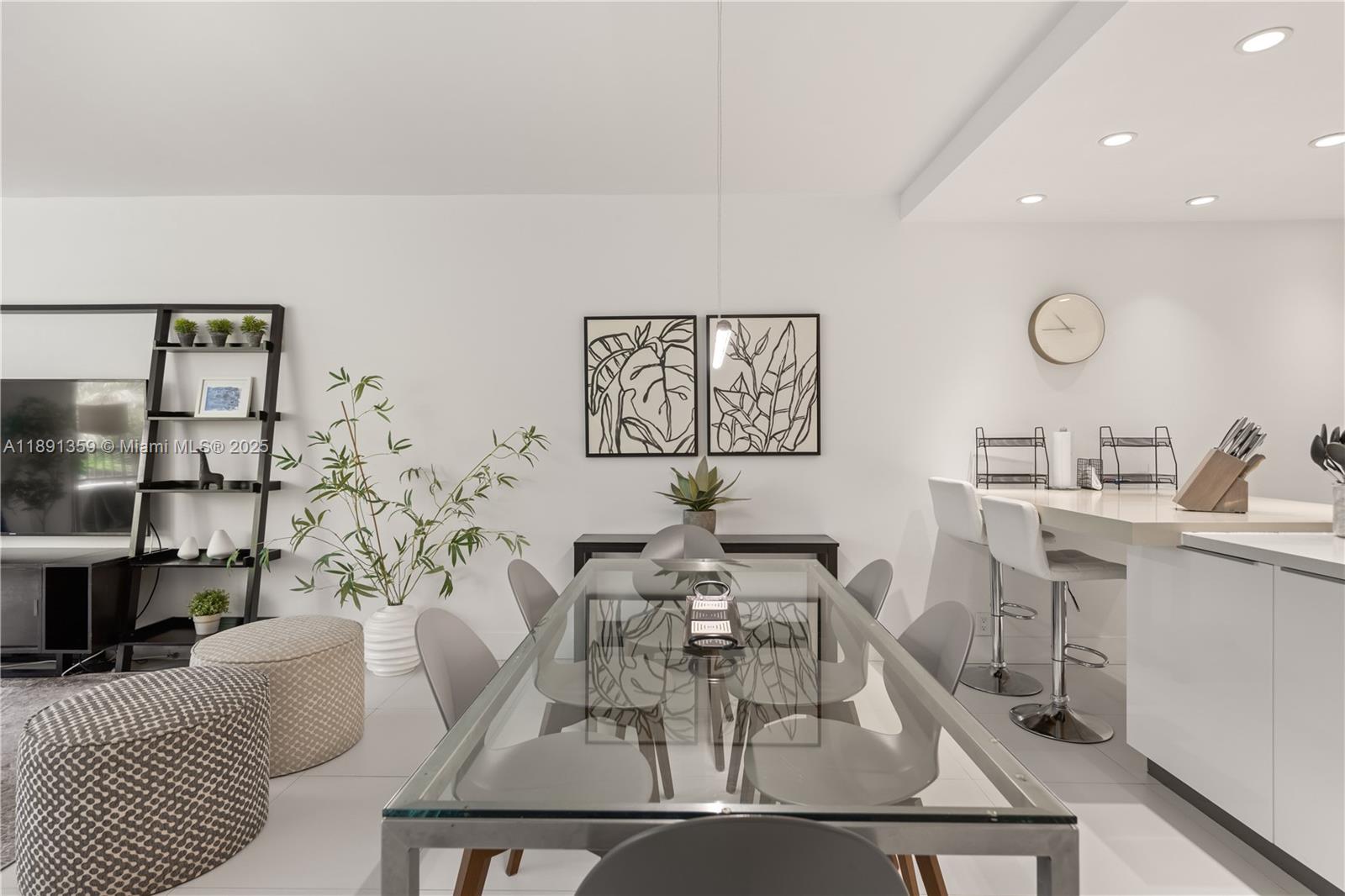 A modern dining area features a glass-topped table, gray chairs, and an adjacent kitchen counter — 101 Crandon Blvd # 379, Key Biscayne FL 33149, KEY BISCAYNE, FL