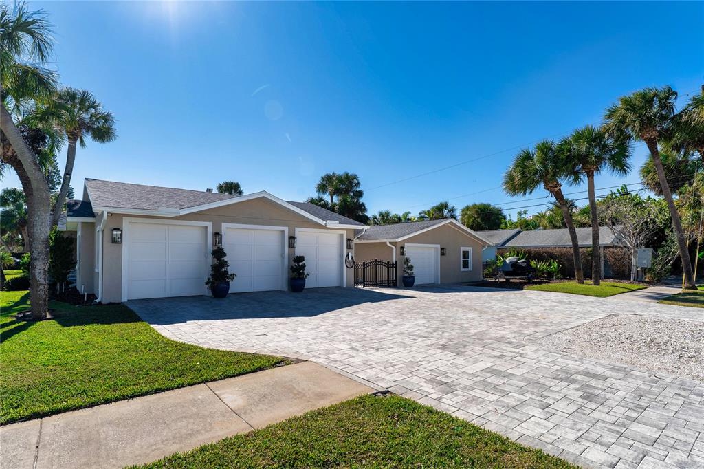 A beige house with a three-car garage and a separate single-car garage with paver driveway — 848 MANDALAY AVENUE, CLEARWATER BEACH, FL