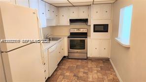 A kitchen with white cabinets, stainless steel appliances, and tiled flooring — SUNNY ISLES BEACH, FL