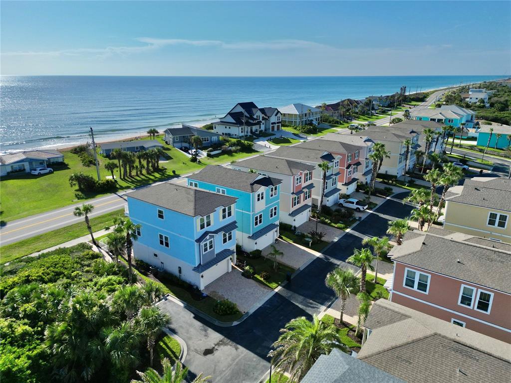 An aerial view shows a row of colorful beach houses near the ocean and road — 2718 SUNSET INLET DRIVE, FLAGLER BEACH, FL
