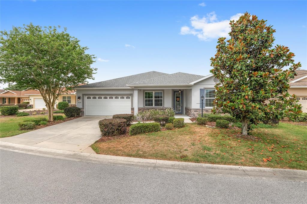 A single-story house with a white garage, gray siding, and a large tree in front — 9326 SW 97TH CIRCLE, OCALA, FL
