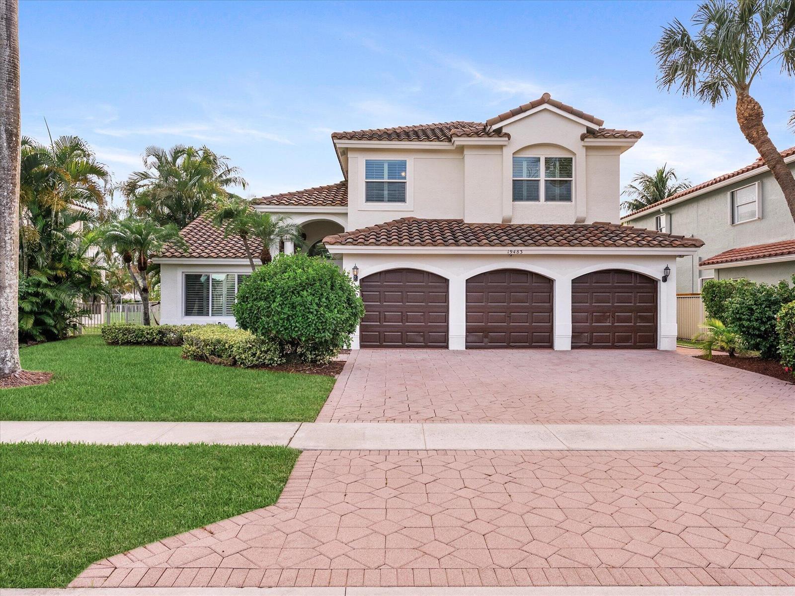 A two-story house with a three-car garage and a paved driveway under a blue sky — 19483 Black Olive Lane, Boca Raton FL 33498, BOCA RATON, FL