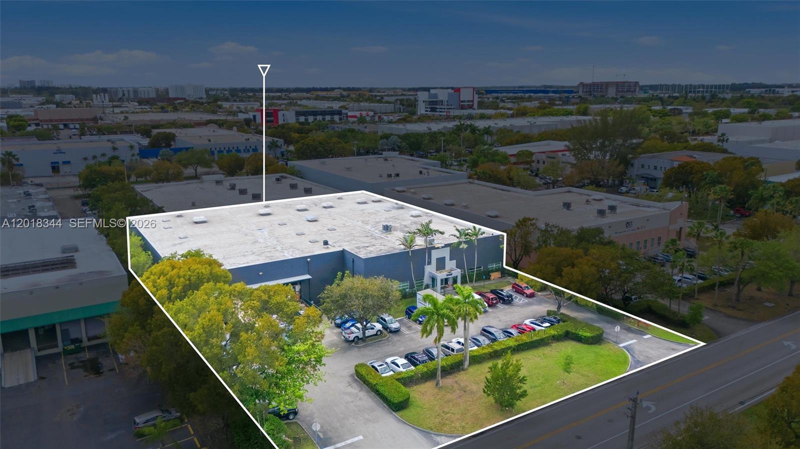 An aerial view shows a commercial warehouse building with a parking lot and green space — 10880 NW 30th St, Doral FL 33172, DORAL, FL