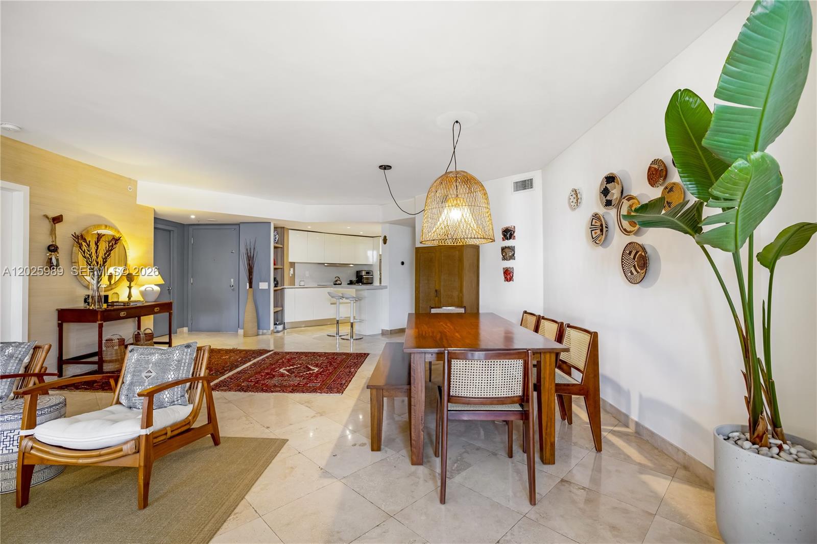 A dining area and living space feature tile floors, a wooden table, and a large plant — 701 Brickell Key Blvd # 512, Miami FL 33131, MIAMI, FL