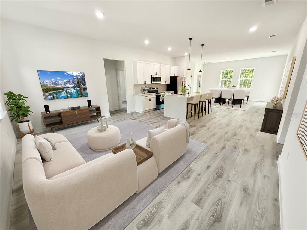 An open-concept living room and kitchen feature light wood-look flooring and white cabinetry — 16242 SW 28TH TERRACE, OCALA, FL