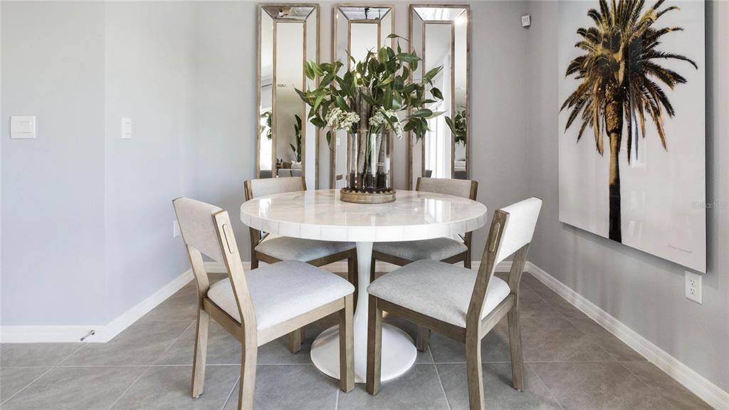 A dining area features a round white table, four chairs, and three wall-mounted mirrors — 2606 GOLDEN TROUT LANE, EDGEWATER, FL