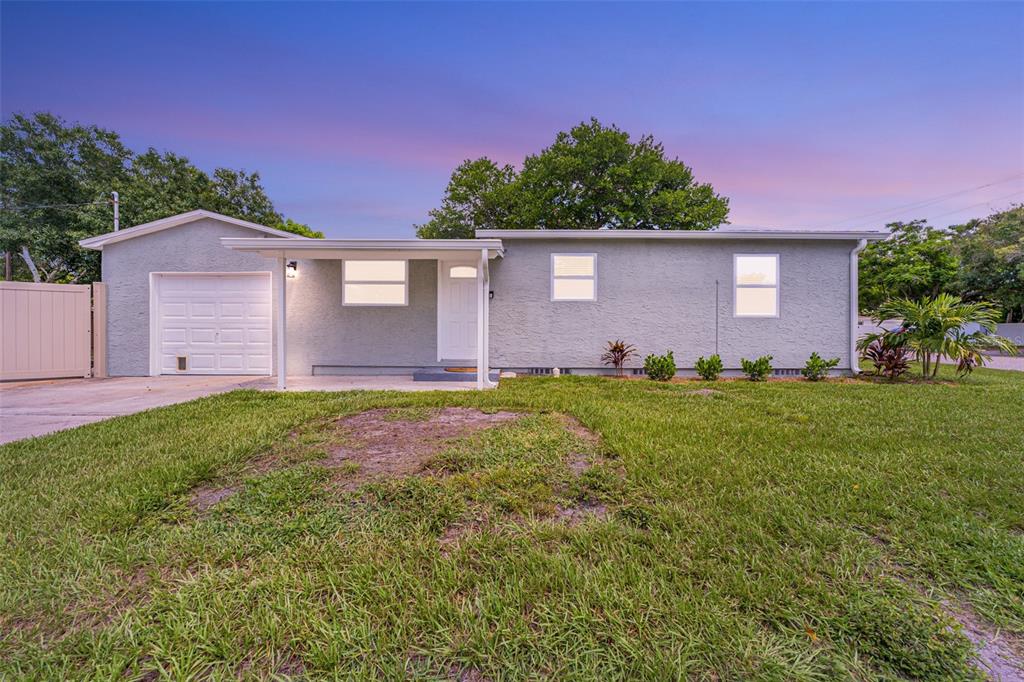 A two-story white house with dark-trimmed windows and an attached garage stands on a lot — 4651 22ND AVENUE N, ST PETERSBURG, FL