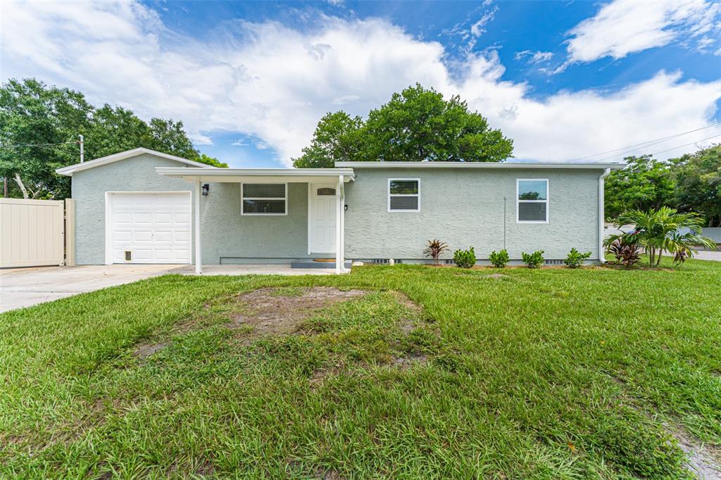 A two-story white house with dark window frames and a palm tree in the yard — 4651 22ND AVENUE N, ST PETERSBURG, FL