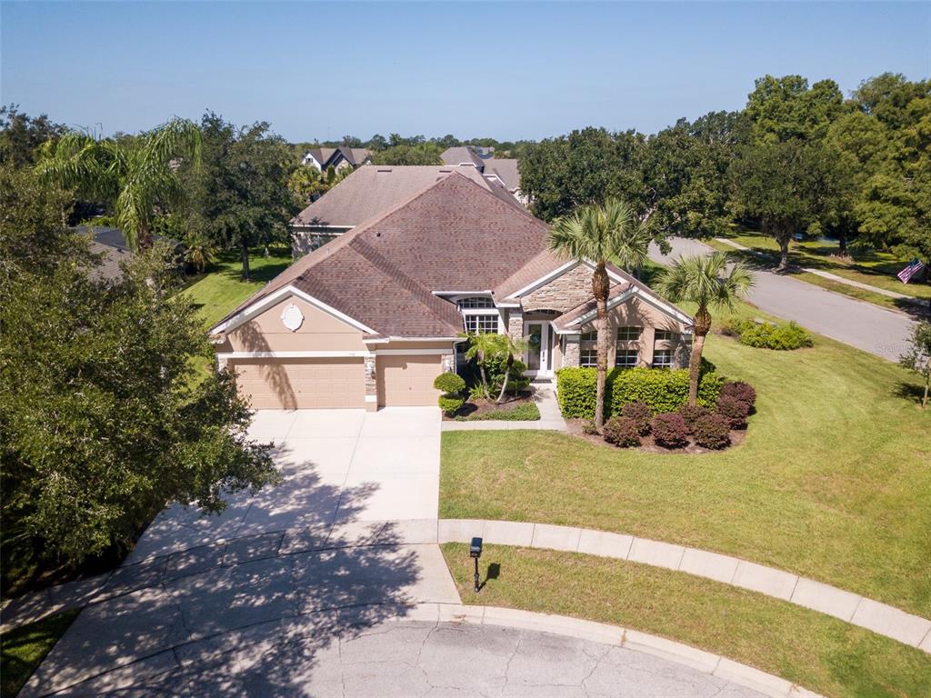 An aerial view of a single-story suburban house with a three-car garage and landscaped yard — 1733 BRIDGETS COURT, KISSIMMEE, FL
