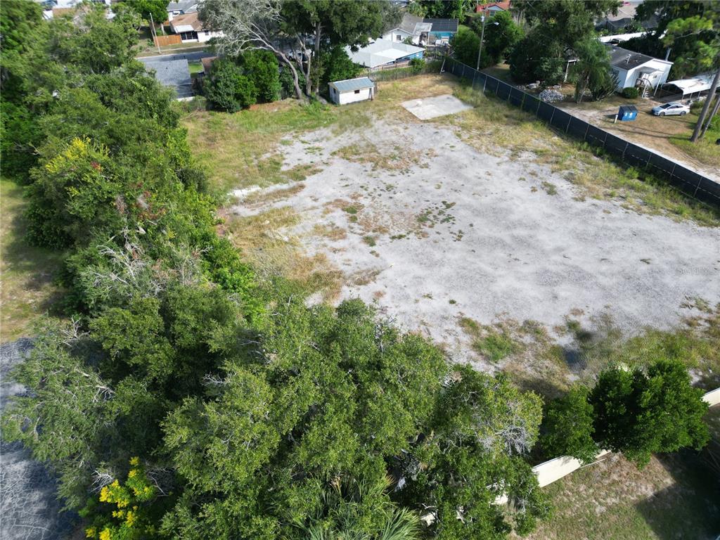 An aerial view shows a large, cleared rectangular lot bordered by trees and a fence — 4155 PINE HAVEN ROAD, NEW PORT RICHEY, FL