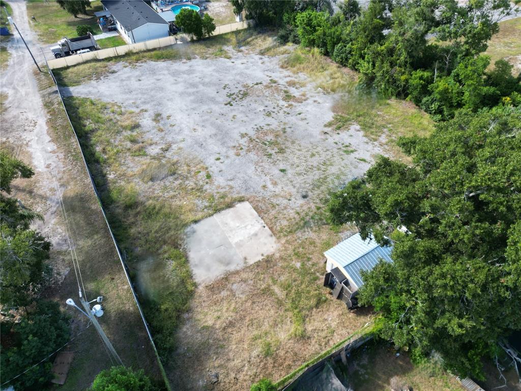 An aerial view shows a cleared, rectangular dirt lot with a small concrete pad — 4155 PINE HAVEN ROAD, NEW PORT RICHEY, FL