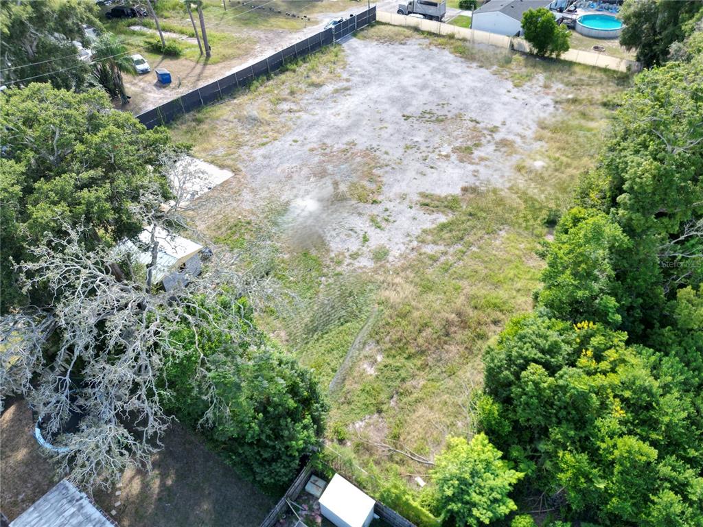 An aerial view shows a vacant, fenced-in rectangular lot with trees and a small structure — 4155 PINE HAVEN ROAD, NEW PORT RICHEY, FL