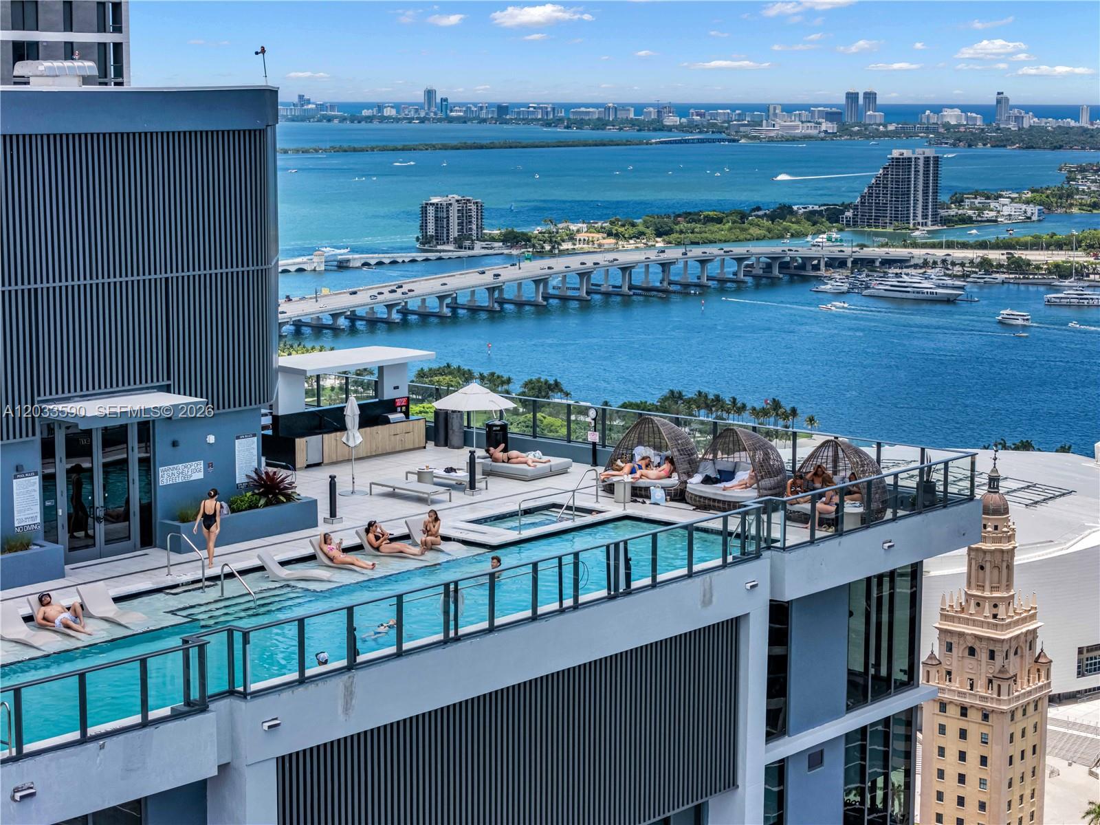 An elevated outdoor swimming pool deck features lounge chairs, cabanas, and views of the bay — 121 NE 5th St # 1400, Miami FL 33132, MIAMI, FL