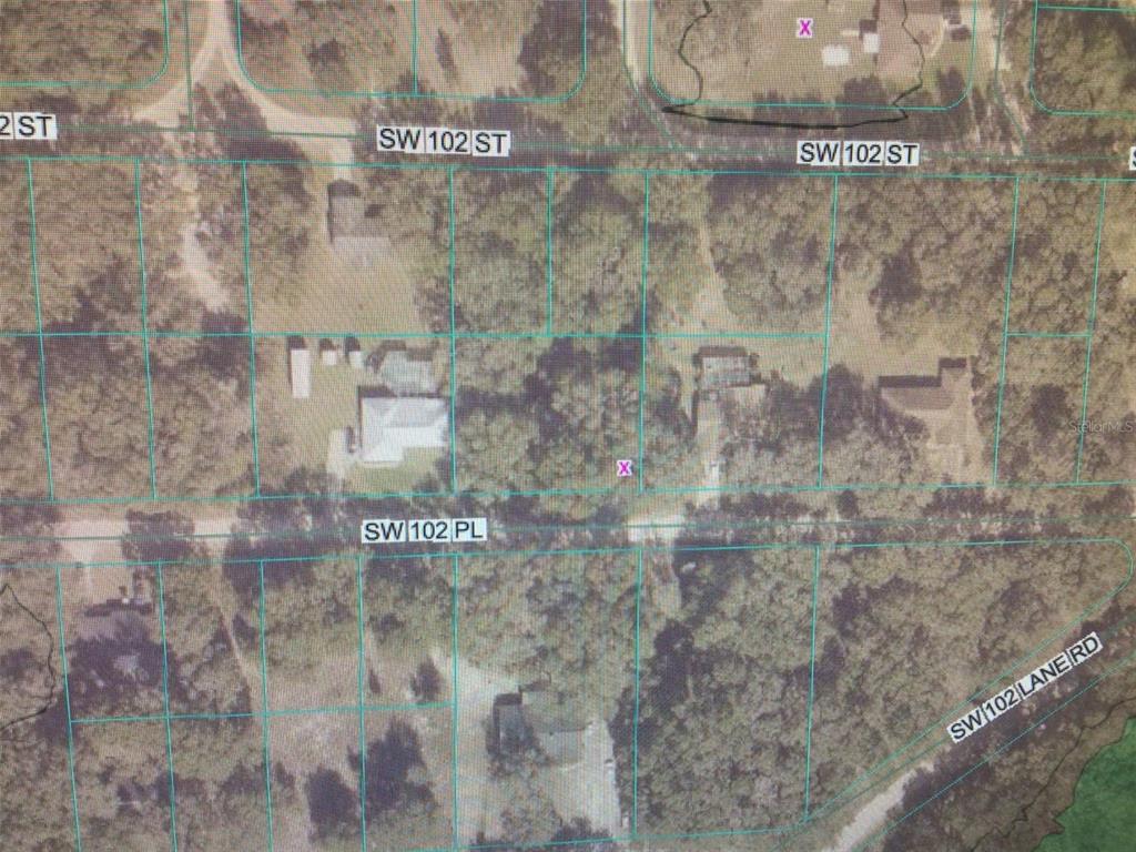 This is an aerial map showing property lot lines, roads, and wooded residential areas — 0 SW 102 PLACE, DUNNELLON, FL
