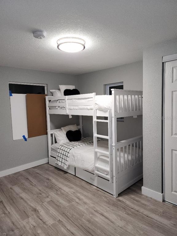 A bedroom features a white bunk bed, light wood-look flooring, and gray walls — 634 FOSTER AVENUE, WINTER GARDEN, FL