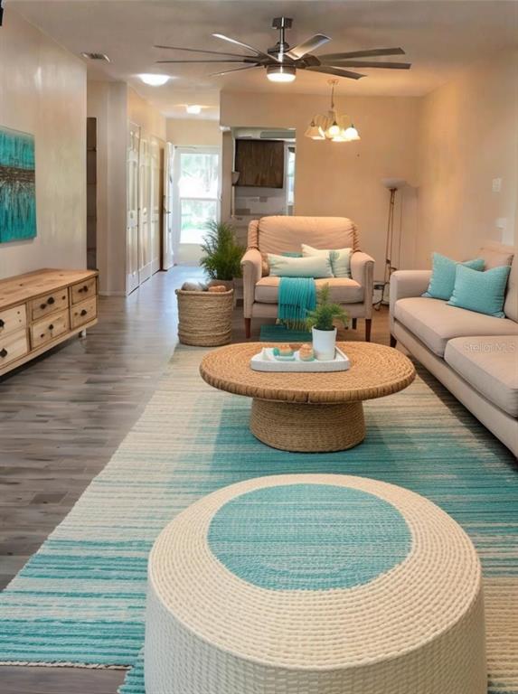 A living room features a blue and white area rug, a round coffee table, and seating — 2687 GOLF COURSE DRIVE UNIT 219, SARASOTA, FL