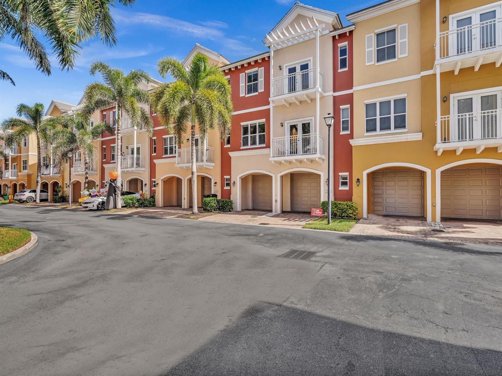 A row of colorful three-story townhouses with attached garages and palm trees in front — 2329 Vintage Drive # 2329, Lighthouse Point FL 33064, LIGHTHOUSE POINT, FL