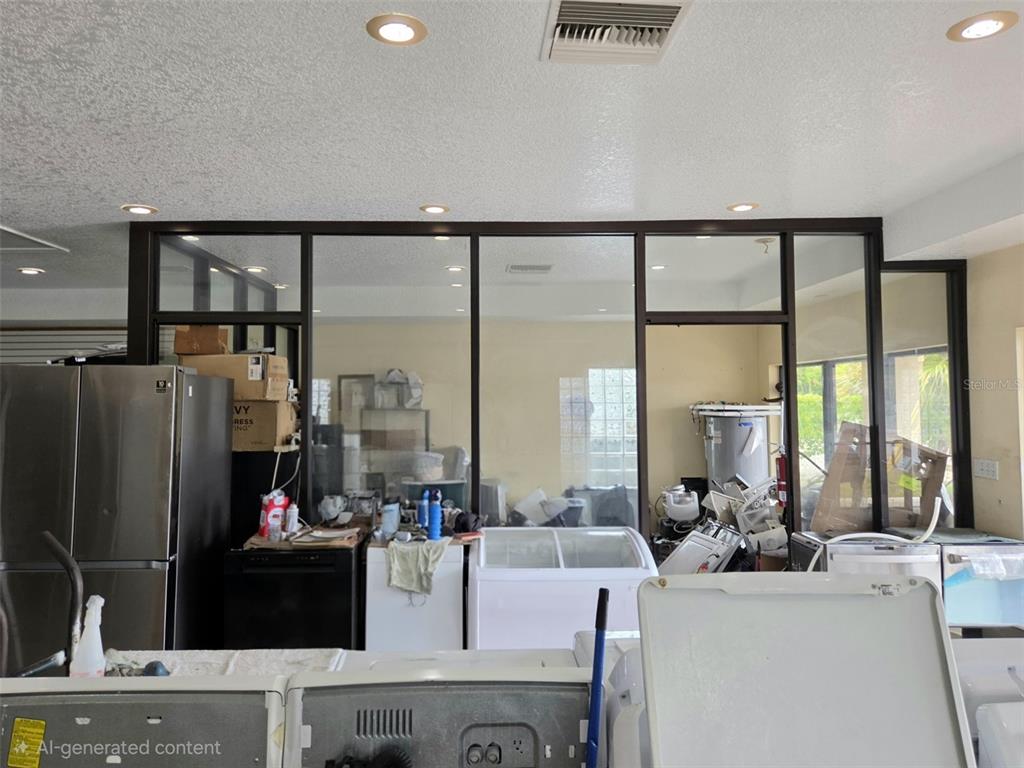 A room with a glass-paneled wall partition separating a laundry area from another space — 6420 N ORANGE BLOSSOM TRAIL, ORLANDO, FL