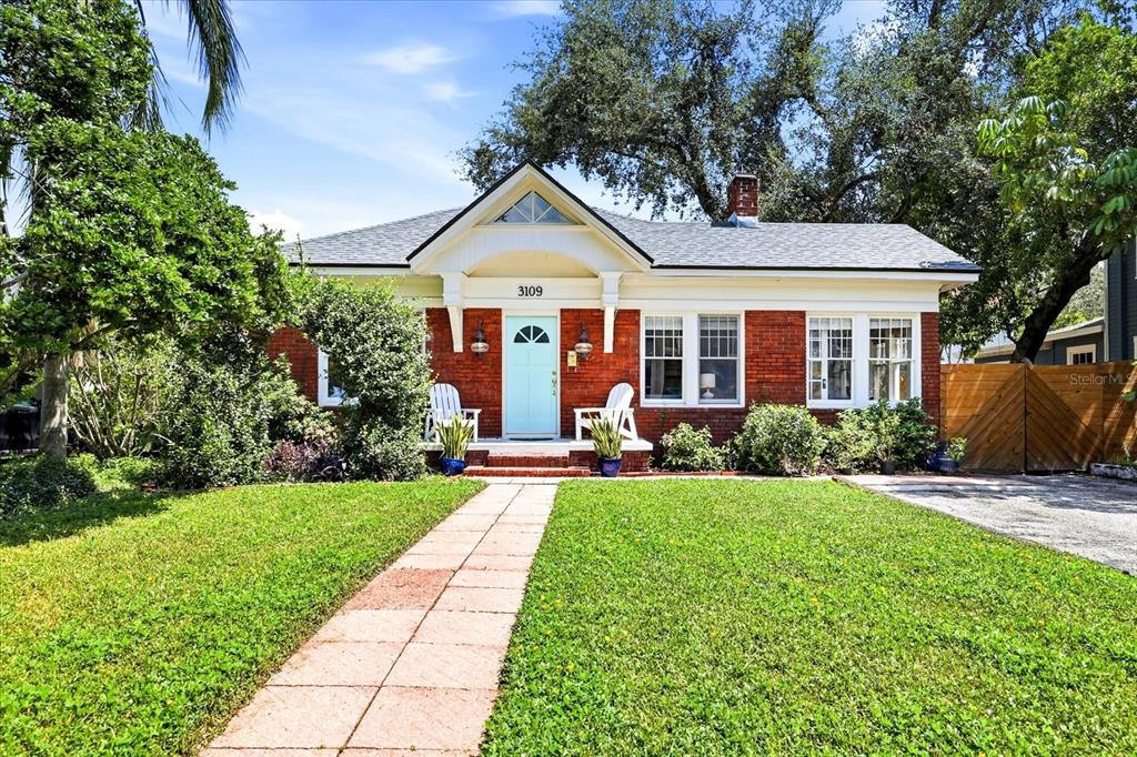 A brick house with a swimming pool and a wooden fence in the backyard — 3109 W SAN CARLOS STREET, TAMPA, FL