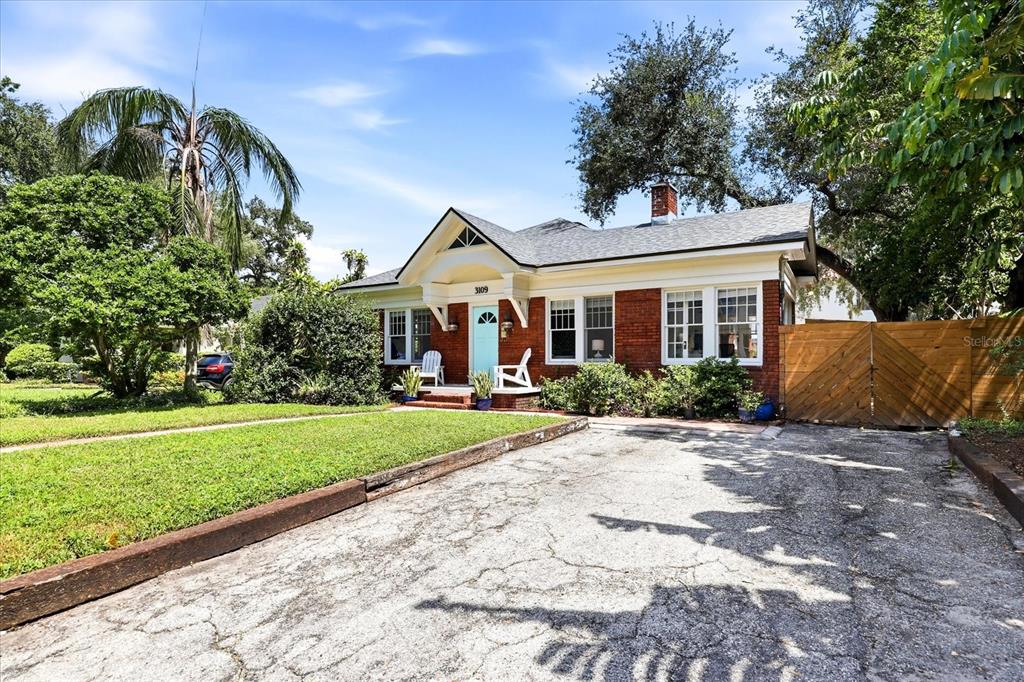 A backyard features a kidney-shaped swimming pool, a wooden privacy fence, and a covered patio — 3109 W SAN CARLOS STREET, TAMPA, FL