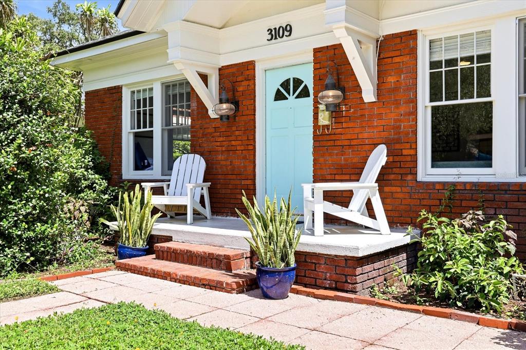 A covered wooden deck with a blue floor, chairs, and a fire pit outdoors — 3109 W SAN CARLOS STREET, TAMPA, FL