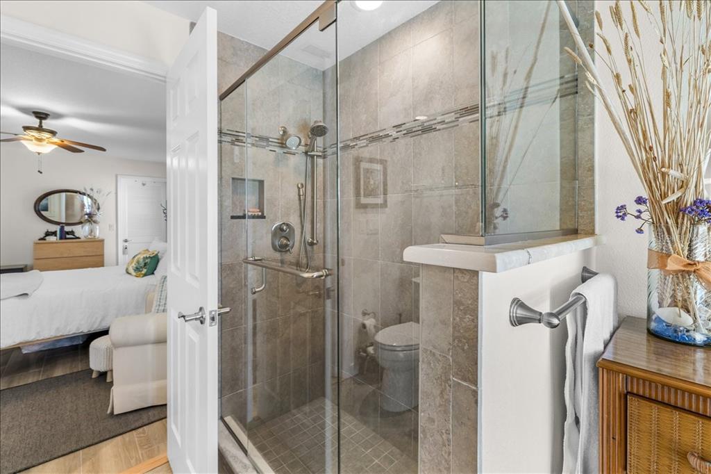 A glass-enclosed shower with tiled walls sits next to a bedroom doorway — 4267 CARLOS COURT, HERNANDO BEACH, FL