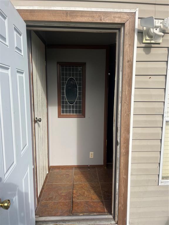 An open exterior door reveals an entryway with tiled flooring and a decorative window — 1145 YAUN ROAD, MOORE HAVEN, FL