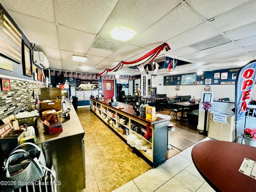 An interior view of a restaurant featuring a long service counter and dining tables — 722 WEST AVENUE, COCOA, FL