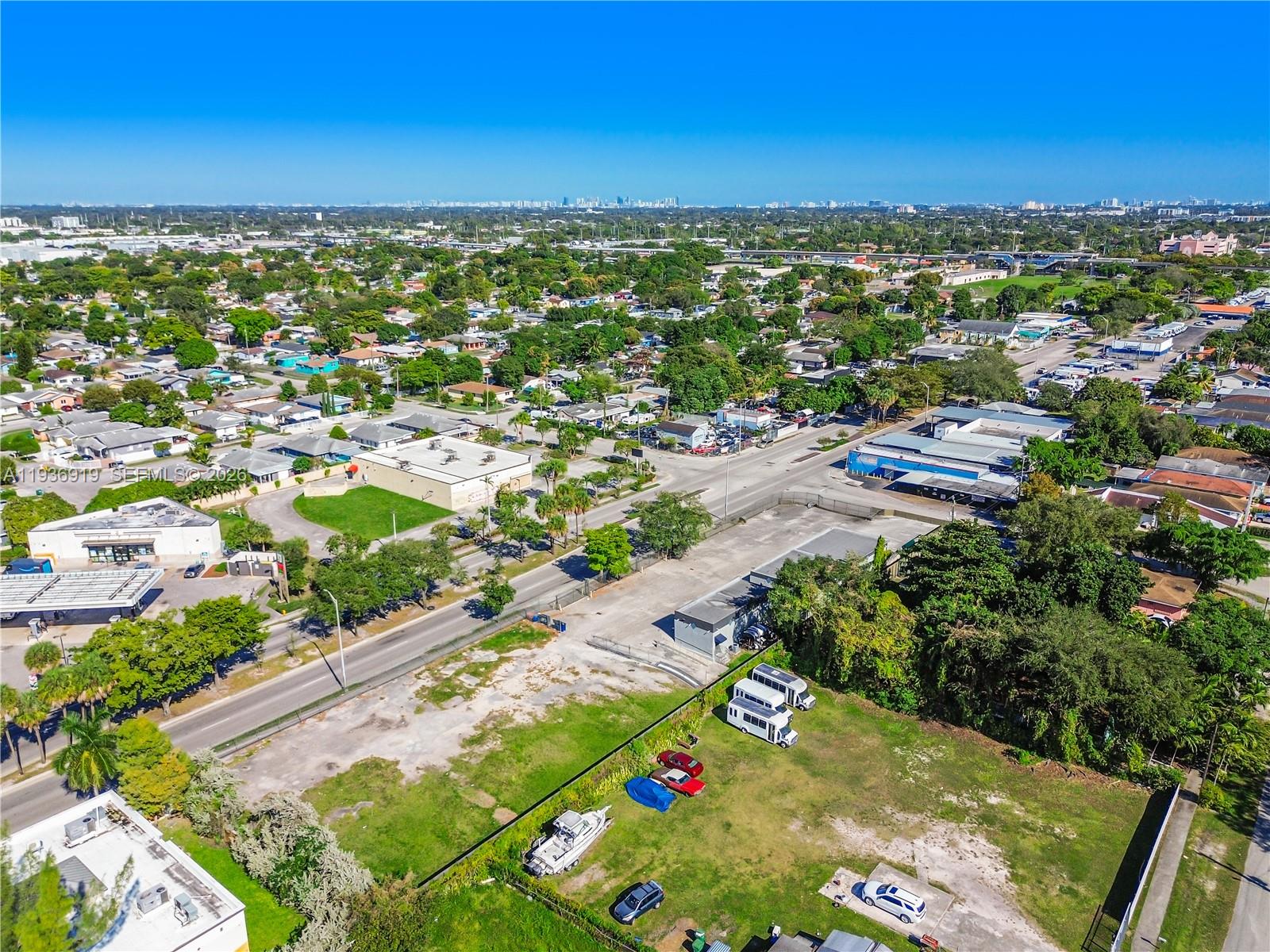 An aerial view shows a vacant lot with parked vehicles next to a commercial street — 3130 NW 62nd St, Miami FL 33147, MIAMI, FL