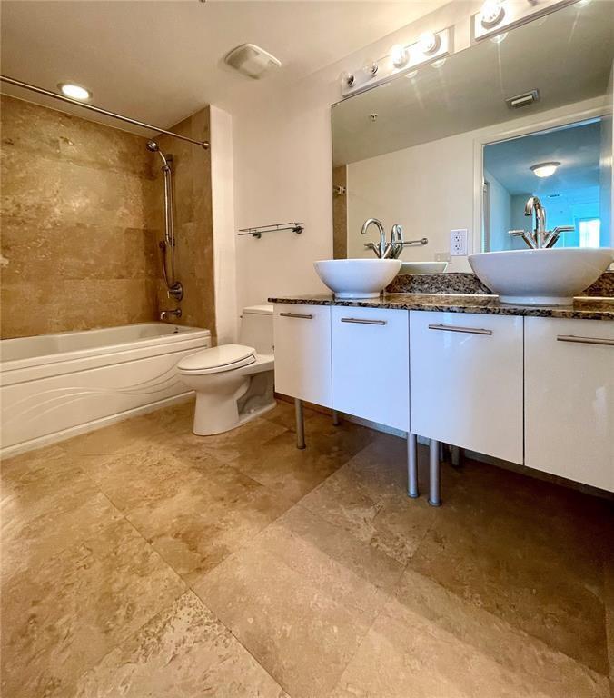 A bathroom features a double vanity with vessel sinks, a toilet, and a tiled tub — 41 SE 5th Street # 1615, Miami FL 33131, MIAMI, FL