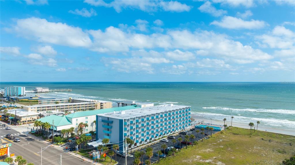 An aerial view shows a multi-story hotel building situated along a sandy beach and ocean — 313 S ATLANTIC AVENUE UNIT 4110, DAYTONA BEACH, FL