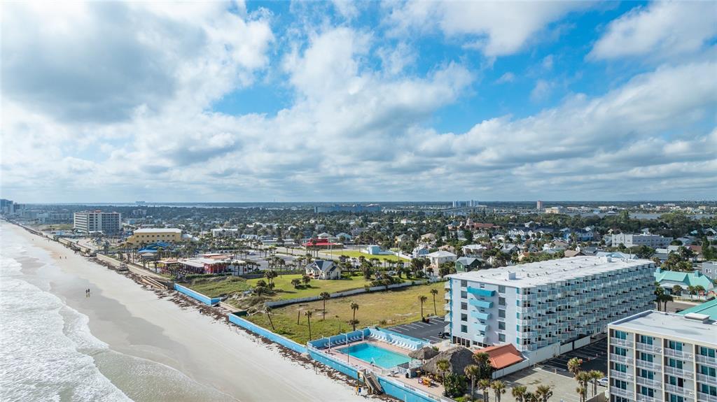 An aerial view shows a beach, a swimming pool, and multi-story hotel buildings — 313 S ATLANTIC AVENUE UNIT 4110, DAYTONA BEACH, FL
