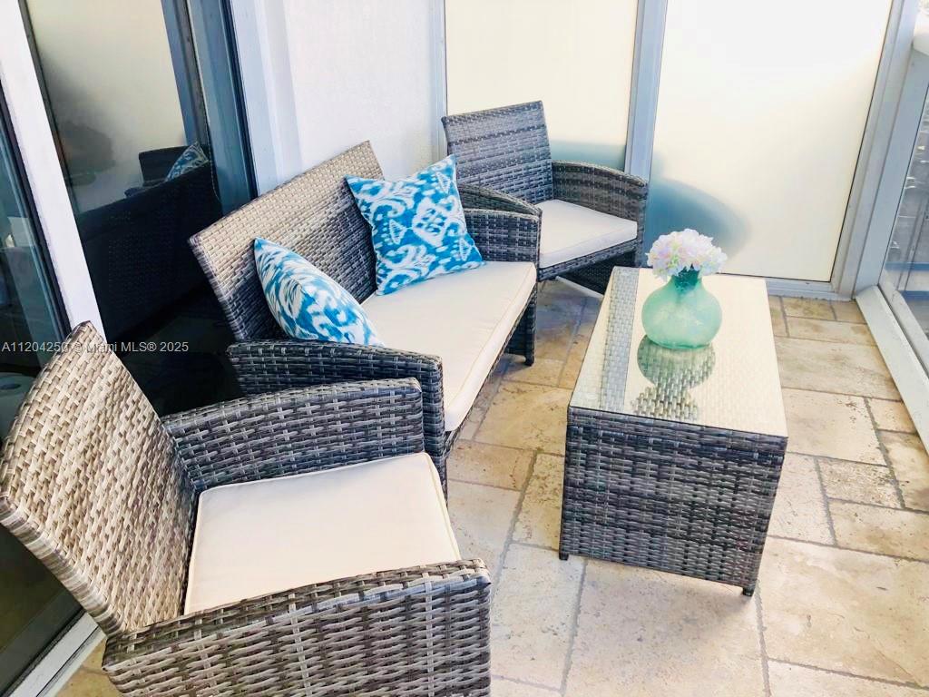 A patio features a wicker sofa and two chairs with white cushions and blue pillows — 1830 S Ocean Dr # 1709, Hallandale Beach FL 33009, HALLANDALE BEACH, FL