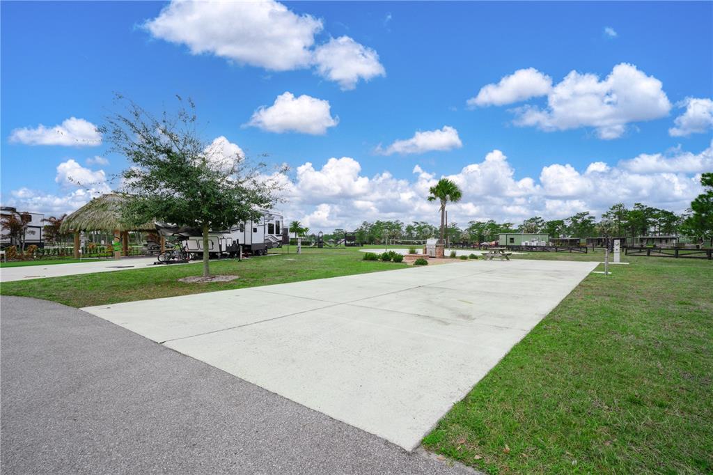 A paved RV pad sits in a grassy lot with a nearby tiki hut structure — 0 HIGHWAY 630 E UNIT 7, LAKE WALES, FL
