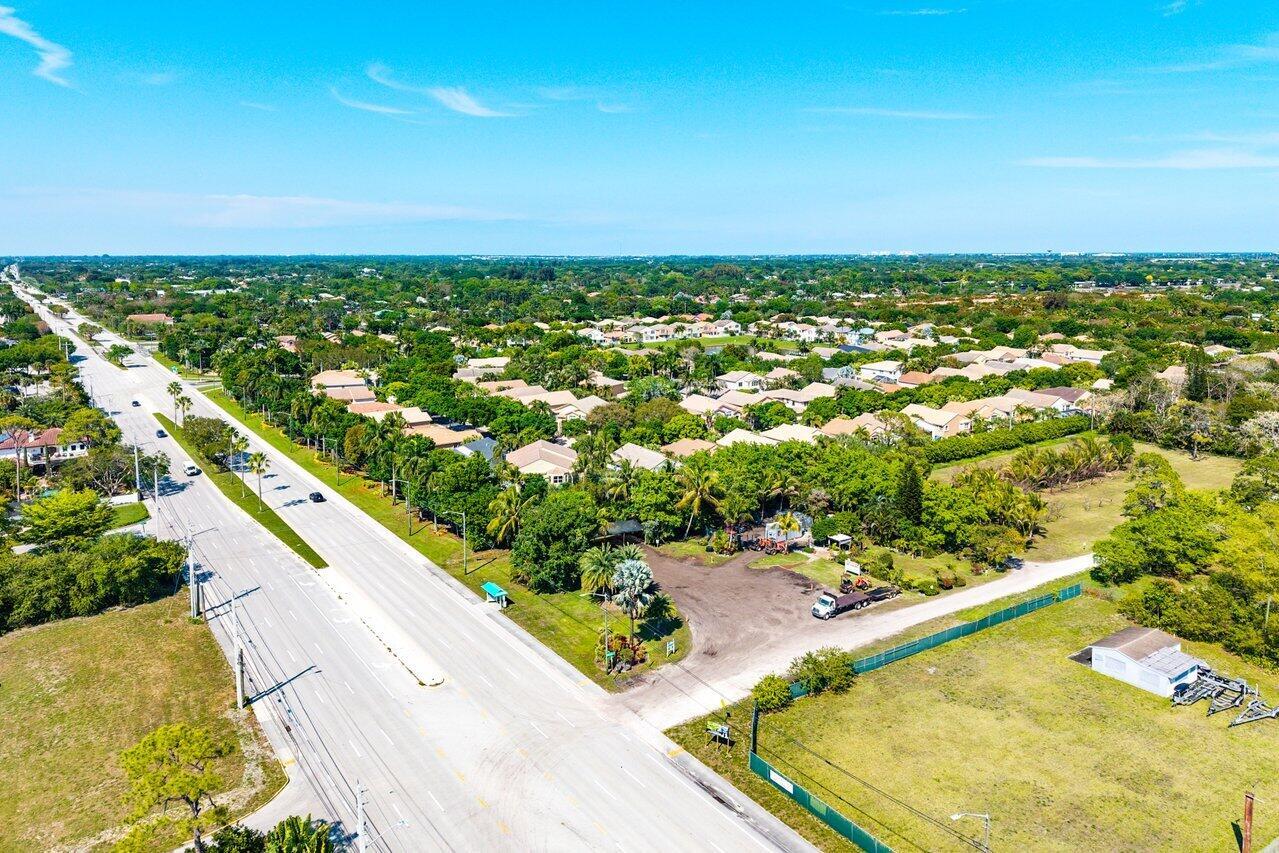 An aerial view shows a multi-lane road bordering a residential neighborhood with lush green trees — 0 S Military Trail, Delray Beach FL 33415, DELRAY BEACH, FL