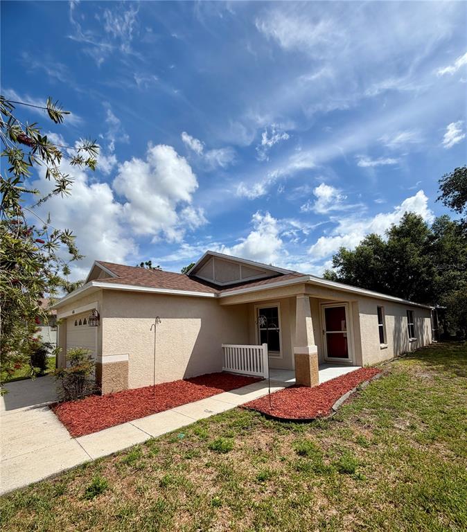 A single-story house with a beige stucco exterior, a brown shingled roof, and red mulch — 4316 OLD WAVERLY COURT, WESLEY CHAPEL, FL