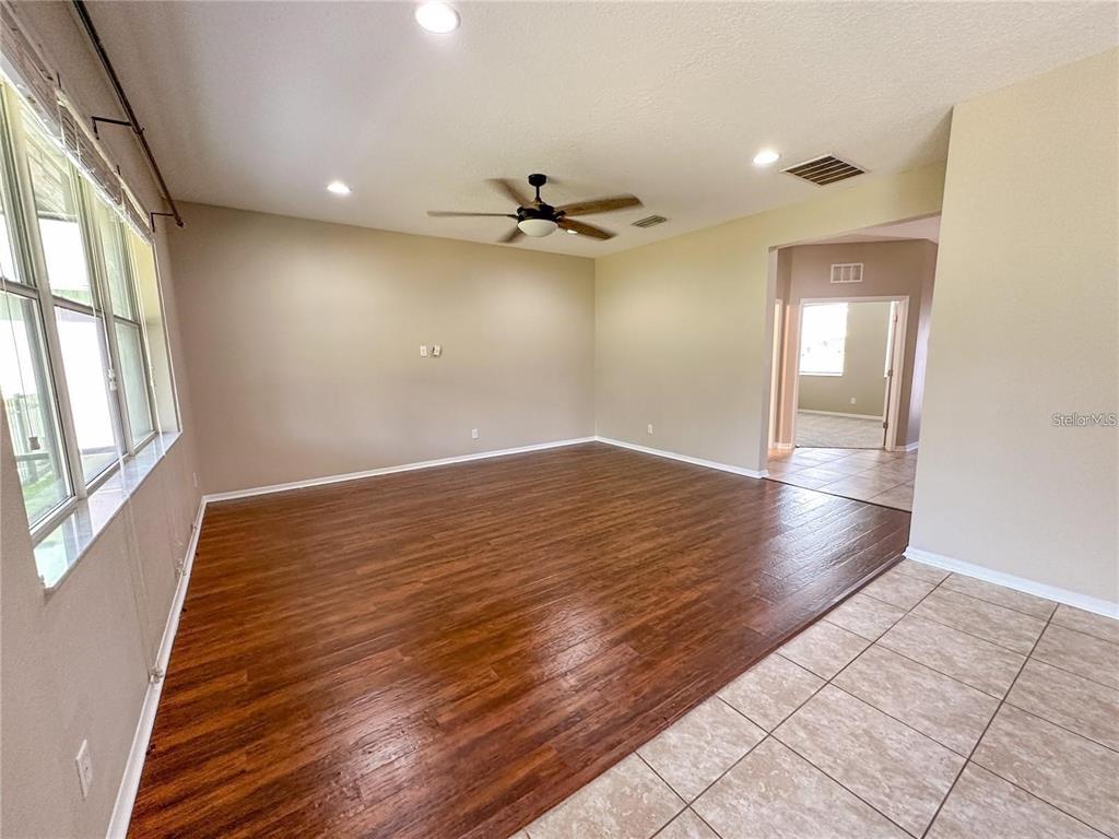 A living room features wood-look flooring, a ceiling fan, and an adjacent tiled entryway — 8979 39TH STREET CIRCLE E, PARRISH, FL