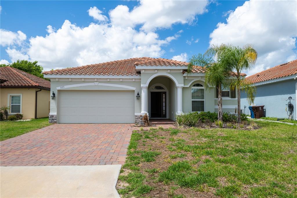 A single-story house with a tiled roof, a brick driveway, and a two-car garage — 375 VILLA SORRENTO CIRCLE, HAINES CITY, FL