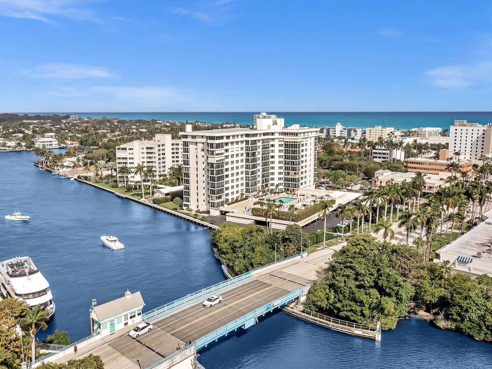 An aerial view shows a multi-story apartment building, a bridge, and boats on a waterway — 50 East Road # 12f, Delray Beach FL 33483, DELRAY BEACH, FL