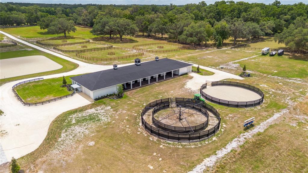 An aerial view shows a horse stable with a round pen and a horse walker — 6170 NW 135TH AVENUE, MORRISTON, FL