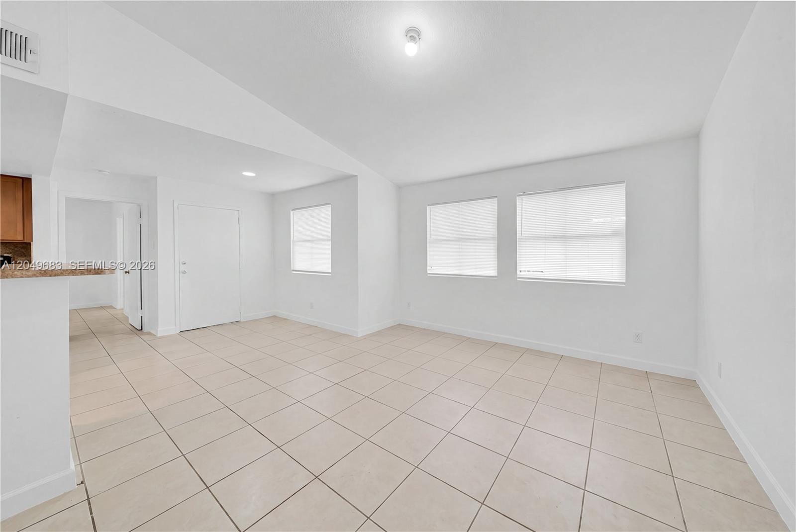 An empty room with white walls, tile flooring, and three windows with blinds — 15070 SW 103rd Ln # 2201, Miami FL 33196, MIAMI, FL