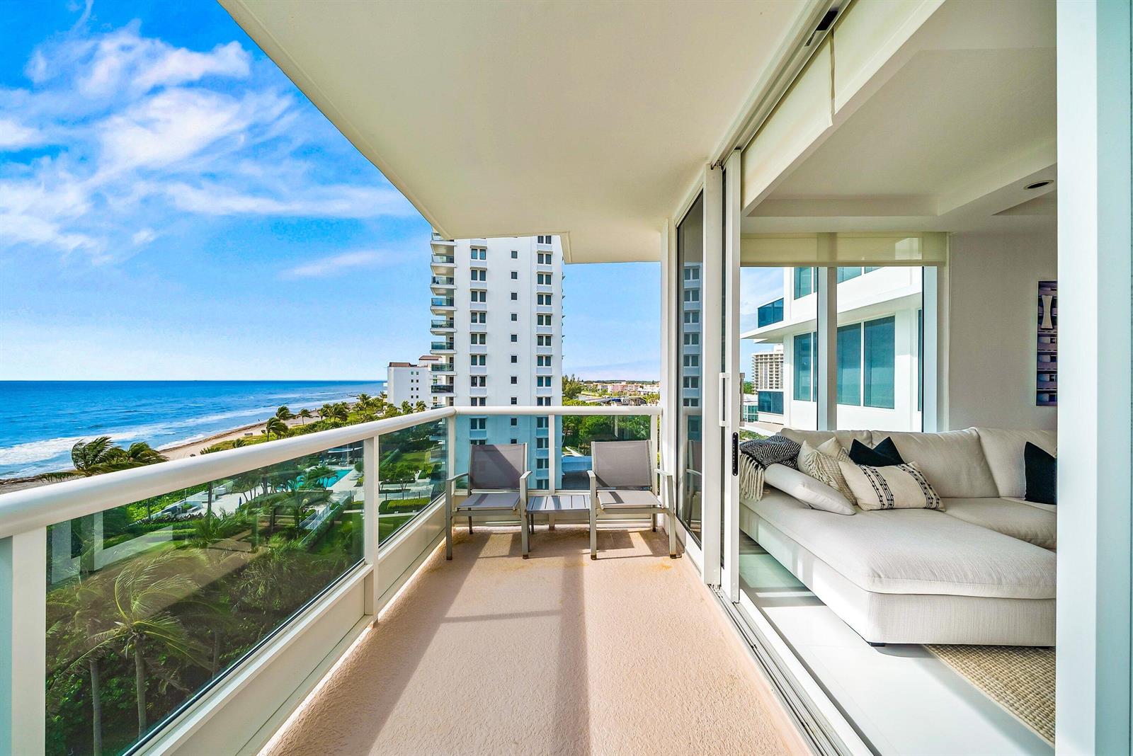 A balcony with two chairs overlooks the ocean and a neighboring high-rise building — 700 S Ocean Boulevard # 705, Boca Raton FL 33432, BOCA RATON, FL