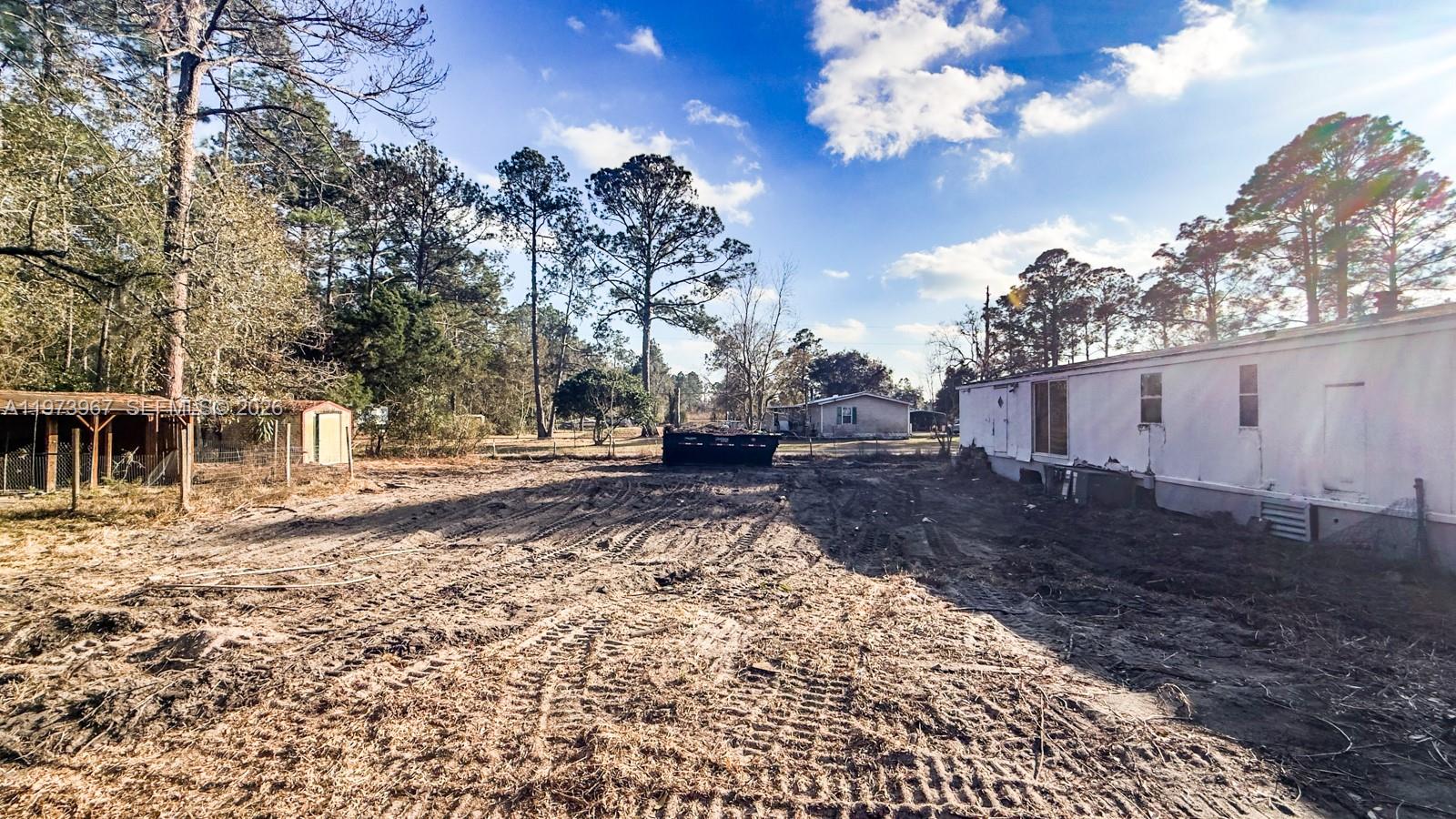 A dirt lot with tire tracks sits between a mobile home and a small shed — 124 Cypress Dr, Palatka FL 32177, PALATKA, FL