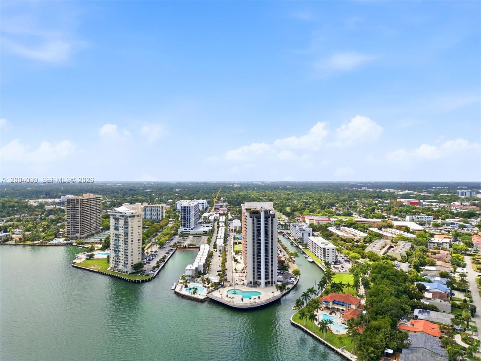 An aerial view shows high-rise residential buildings situated on a peninsula surrounded by water — 1800 NE 114th St # 1505, Miami FL 33181, MIAMI, FL