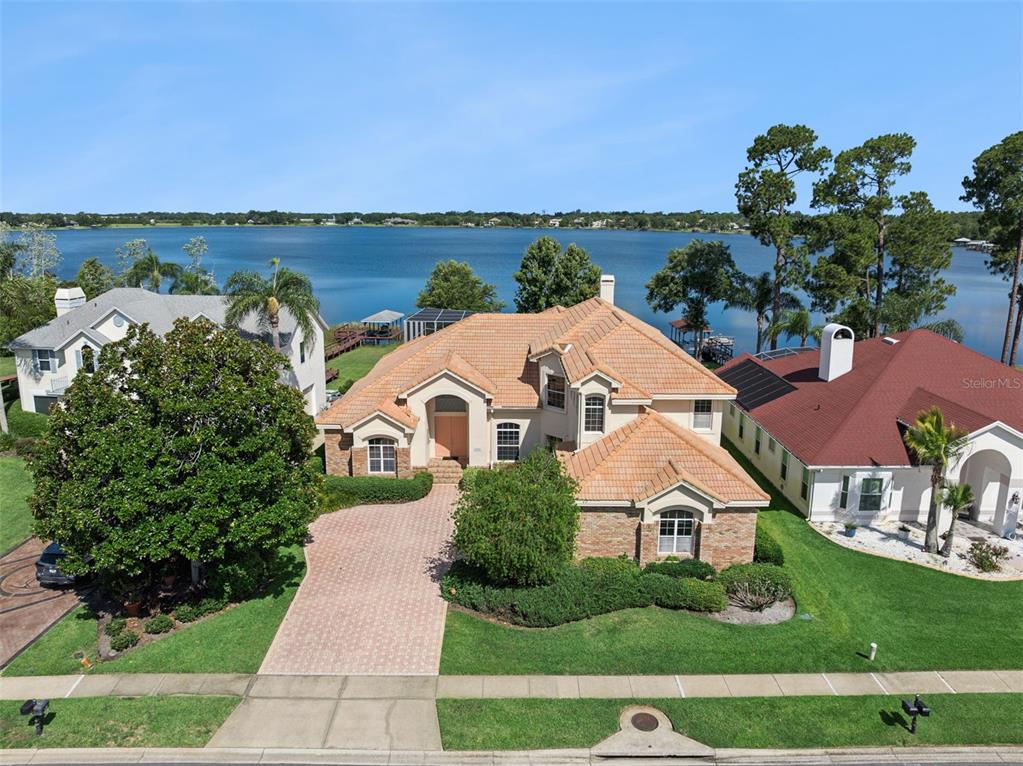An aerial view of a two-story house with a tile roof facing a lake — 1901 EDGEWATER DRIVE, MOUNT DORA, FL