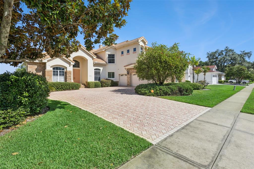 A two-story suburban house with a paved driveway, manicured lawn, and a multi-car garage — 1901 EDGEWATER DRIVE, MOUNT DORA, FL