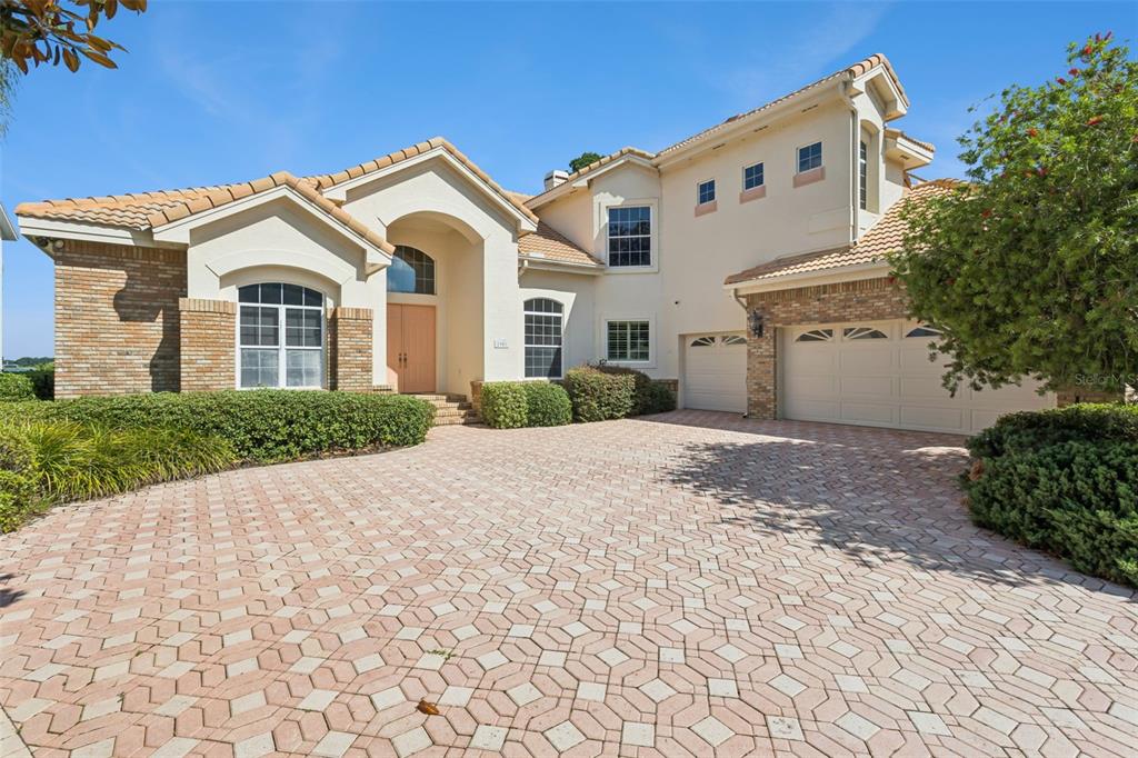 A two-story stucco house with a tiled roof and a paved driveway — 1901 EDGEWATER DRIVE, MOUNT DORA, FL