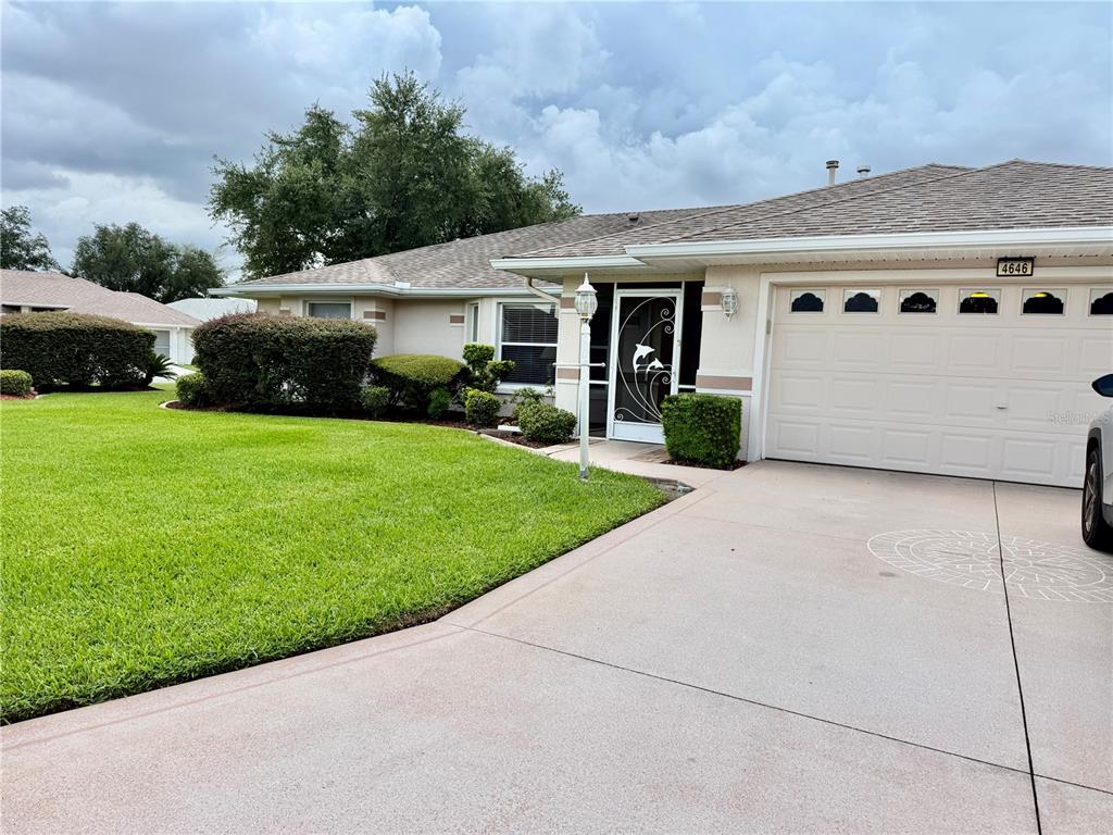 The exterior of a single-story house features a screened-in porch, a lawn, and palm trees — 4646 INVERNESS DRIVE, LEESBURG, FL