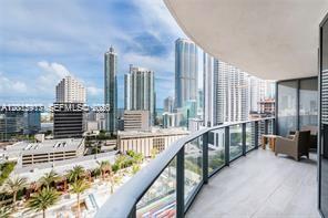 A balcony with a glass railing overlooks a city skyline with multiple high-rise buildings — 45 SW 9th St # 1701, Miami FL 33130, MIAMI, FL